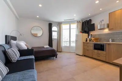 a living room with a couch and a kitchen at Palais Saint Pierre in Cagnes-sur-Mer