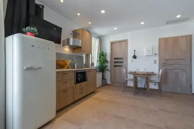 a kitchen with a white refrigerator and a table at Palais Saint Pierre in Cagnes-sur-Mer