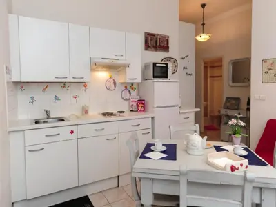 a kitchen with white cabinets and a table and a table and chairs at La Romantica Dante Five stars Holiday House in Nice