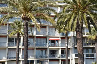 a hotel with palm trees in front of it at Le Grand Sud in Nice