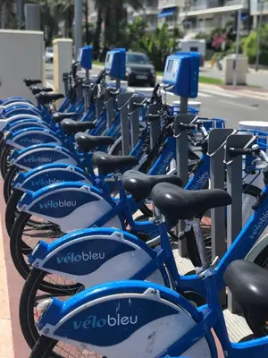 a row of blue bikes parked next to a street at Le Grand Sud in Nice