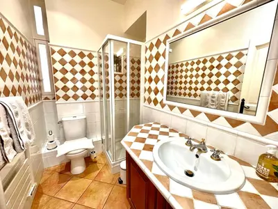 a bathroom with a sink and a toilet and a mirror at Résidence Place Poullan in Villefranche-sur-Mer