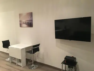 a flat screen tv hanging on a wall with a desk at Gallo Comfort in Nice