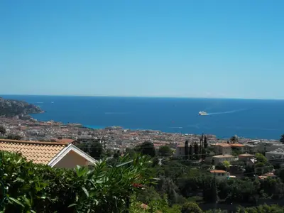 an airplane is flying over a city and the ocean at Bellevue in Nice