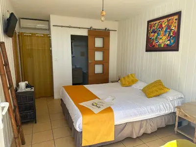 a bedroom with a large white bed with yellow pillows at Hôtel La Fiancée du Pirate in Villefranche-sur-Mer
