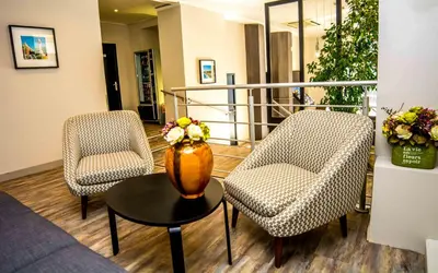 a lobby with two chairs and a vase on a table at Hotel Saint Gothard in Nice