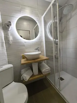 a bathroom with a sink and a toilet and a mirror at Hotel Saint Gothard in Nice