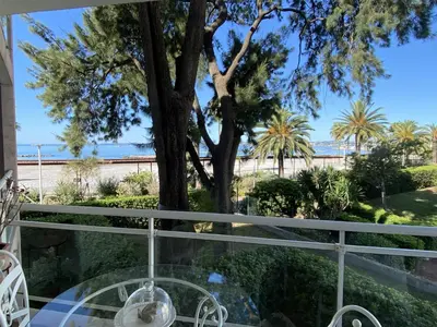 a balcony with a table and a view of the beach at Appartement sur la Plage, Le Royal Beach in Saint-Laurent-du-Var