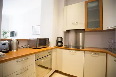 a kitchen with white cabinets and a microwave at Le Coin Du Marché in Nice