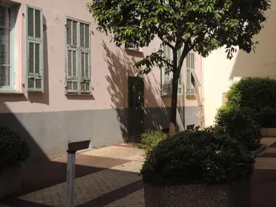 a building with a tree in front of a building at Le Coin Du Marché in Nice
