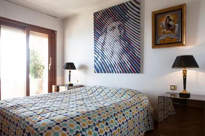a bedroom with a bed and a painting on the wall at Sunny Panoramic Balcony in Èze