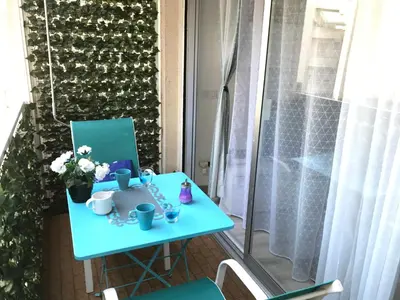 a table on the balcony with cups and flowers at Le Paradis Blue in Nice
