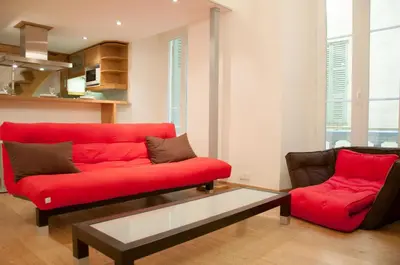 a living room with a red couch and a coffee table at Apartment Massena - Old Town in Nice