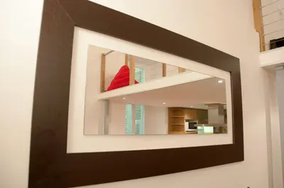 a mirror on a wall with a red chair in it at Apartment Massena - Old Town in Nice