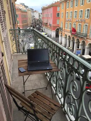 a laptop computer sitting on a table on a balcony at 2 Bedrooms Appartement In Central Location on the famous Place Massena Nice in Nice