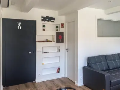 a living room with a couch and a black door at Nicolago in Nice