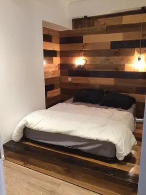 a bed in a room with a wooden wall at Nicolago in Nice