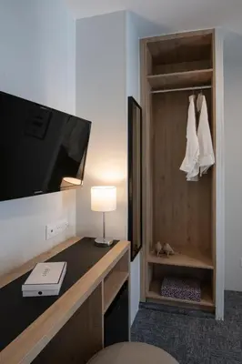 a room with a tv and a desk with a lamp at Bristol Nice in Nice