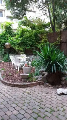 a garden with a table and chairs and plants at Studio dans la Villa 