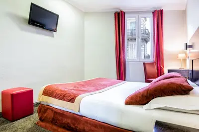 a hotel room with a bed and a window at Hotel De Suède in Nice
