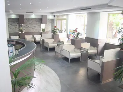 a waiting room with white chairs and tables at Hotel De Suède in Nice