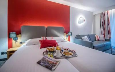 a hotel room with a bed with a tray of food on it at Promotel in Carros