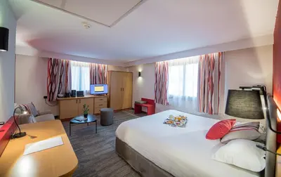 a hotel room with a large bed and a desk at Promotel in Carros