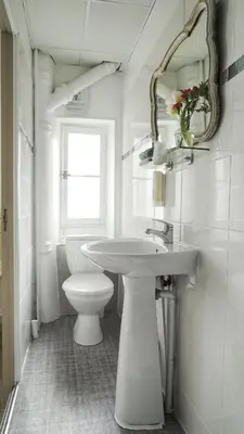 a white bathroom with a sink and a toilet at Hotel des Dames in Nice