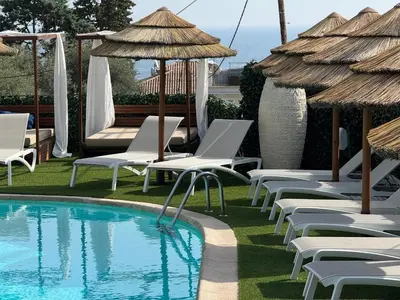 a swimming pool with lounge chairs and umbrellas next to a resort at Boutique Hotel & Spa la Villa Cap Ferrat in Saint-Jean-Cap-Ferrat