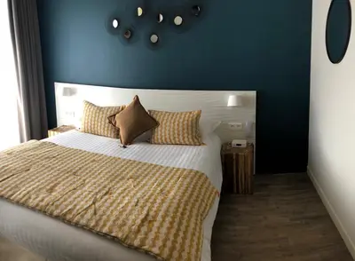 a bedroom with a large bed with a blue wall at Boutique Hotel & Spa la Villa Cap Ferrat in Saint-Jean-Cap-Ferrat