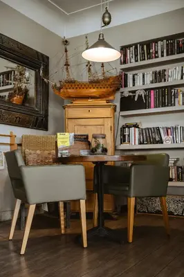 a dining room with a table and chairs and bookshelves at Hôtel du Bord de Mer 