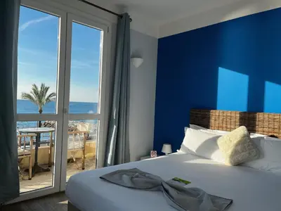 a bedroom with a bed with a view of the ocean at Hôtel du Bord de Mer 