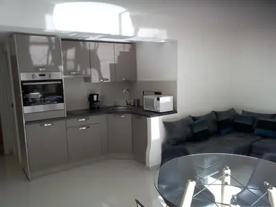 a living room with a kitchen and a couch at Villa du Chateau in Nice