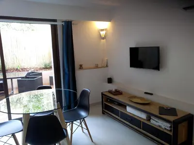 a living room with a glass table and a television at Villa du Chateau in Nice