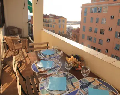 a table on a balcony with a view of a building at Le Lympia in Nice