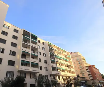 a white apartment building with trees in front of it at Le Lympia in Nice
