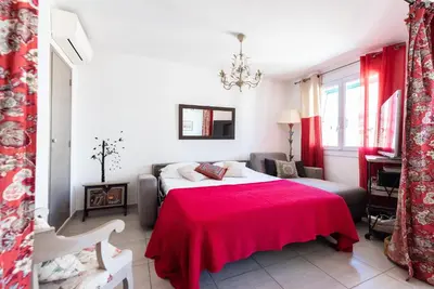 a bedroom with a bed with a red blanket at Le Lympia in Nice