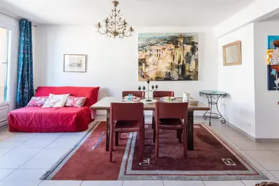 a living room with a table and a red couch at Le Lympia in Nice