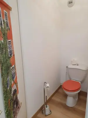 a bathroom with a toilet with a red seat at Oranger in Nice