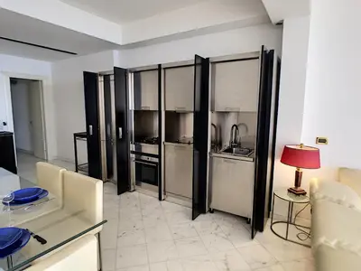 a kitchen with stainless steel appliances and a table and chairs at Nestor&Jeeves - PALAIS DE FRANCE - Central - Sea front in Nice