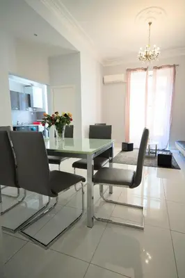 a dining room with a glass table and chairs at Designer Flat Nice in Nice
