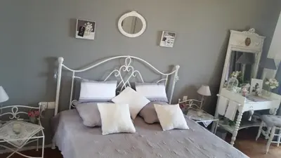 a bedroom with a bed with pillows and a mirror at La Tuiliere in Saint-Laurent-du-Var