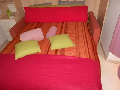 a bed with red and yellow pillows on it at Breakfast at Sophy's in Nice