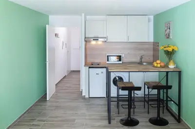 a kitchen with a counter and chairs in a room at Cosy apartment Promenade des Anglais in Nice