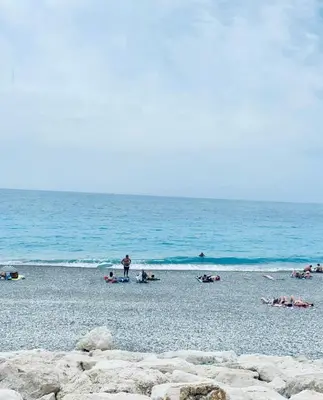 a group of people on a beach near the ocean at Sea View - Promenade des Anglais 1 Bdr in Nice