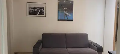 a couch sitting under two pictures on a wall at Nice Centre, Superbe Studio Proche Mer in Nice