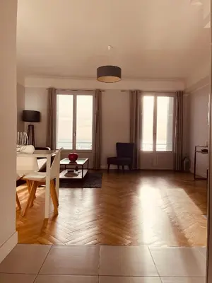 a living room with a table and a dining room at Appartement 2 chambres avec Terrasse Vue sur la Mer in Nice