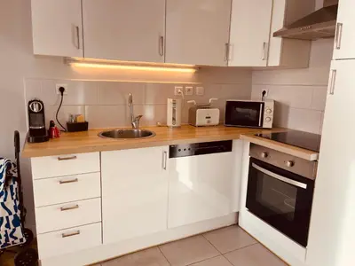 a kitchen with white cabinets and a sink and a microwave at Appartement 2 chambres avec Terrasse Vue sur la Mer in Nice