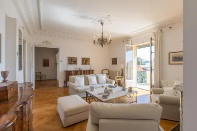 a living room with white furniture and a chandelier at Penthouse Lou Lòu by iVillamia com in Nice