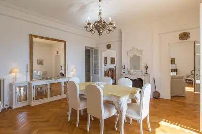 a dining room with a table and white chairs at Penthouse Lou Lòu by iVillamia com in Nice